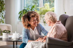 Friendly caregiver supporting an eldery lady